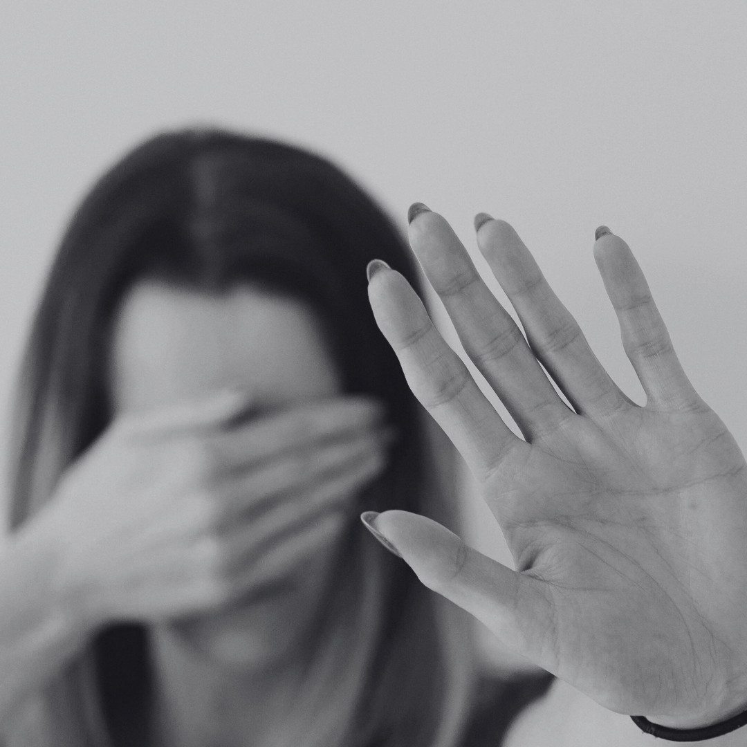 Woman with hand outstretched and other hand over eyes