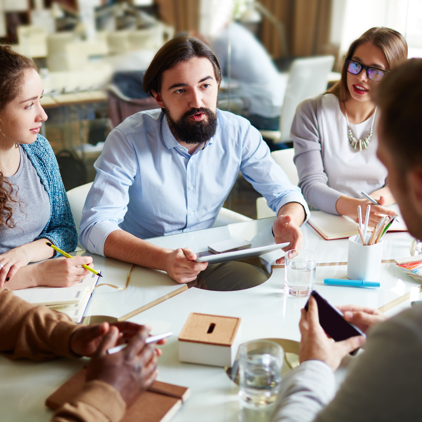 Group talking around a table with documents and notepads