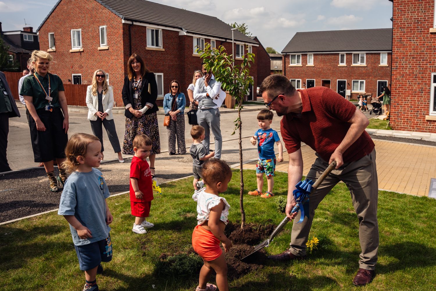 Tree being planted by councillor meredith with help of local children