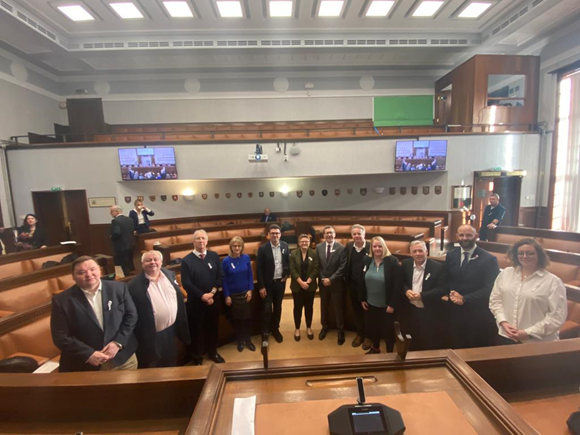 The 10 leaders of Greater Manchester wearing White Ribbons in Salford Council Chamber.