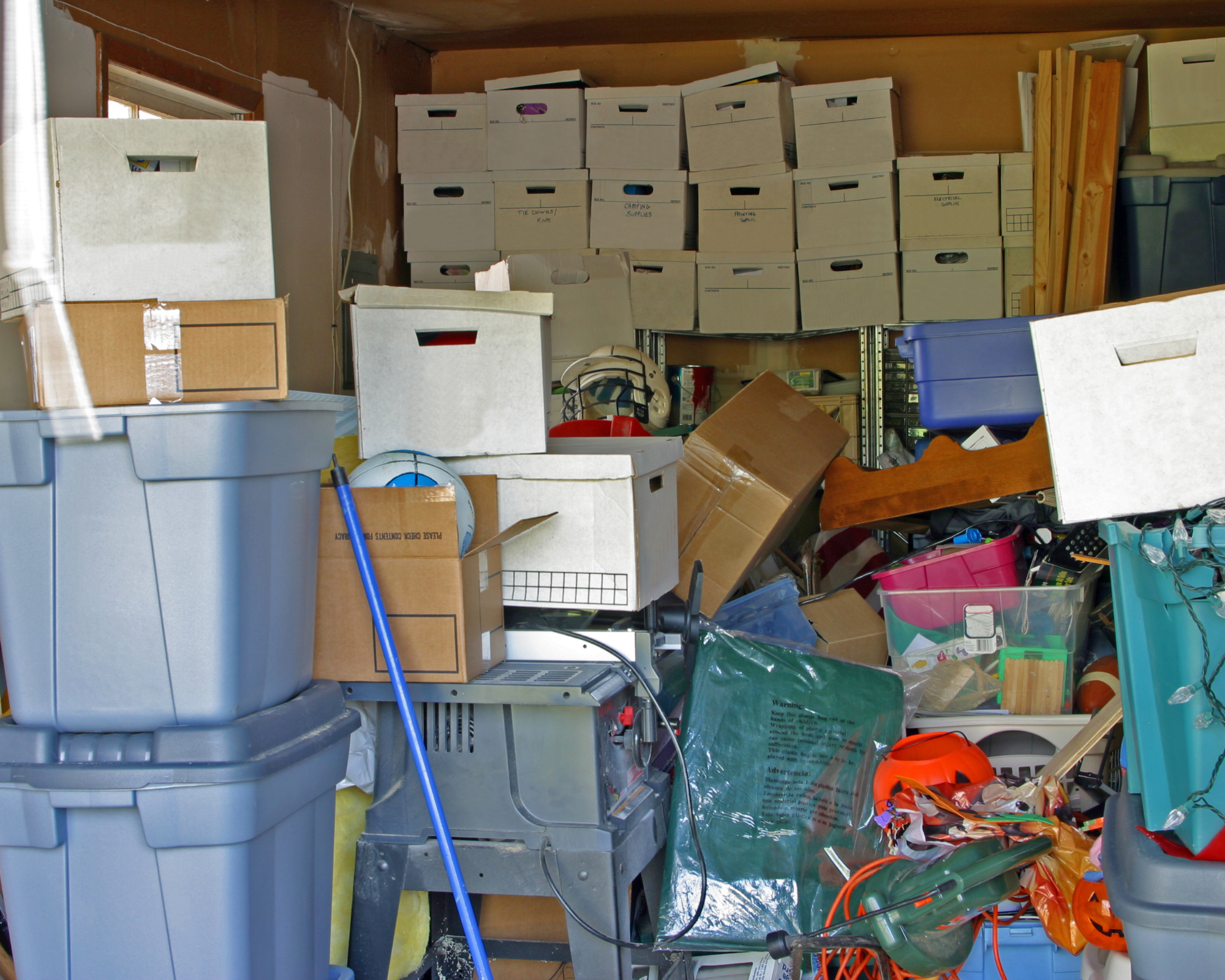 Image of a cluttered room with boxes and items piled high 
