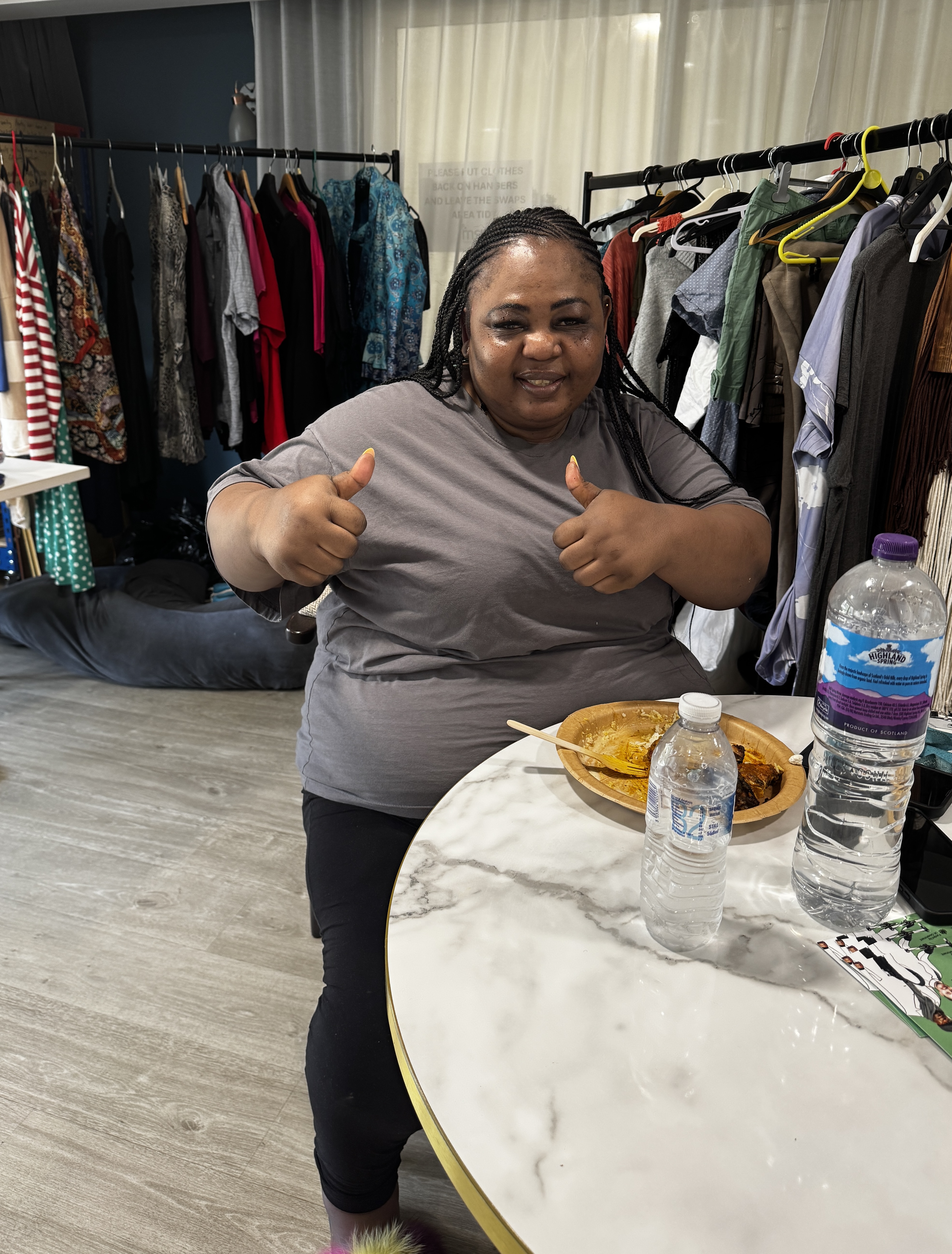 Lady smiling with thumbs up at table with plate of food