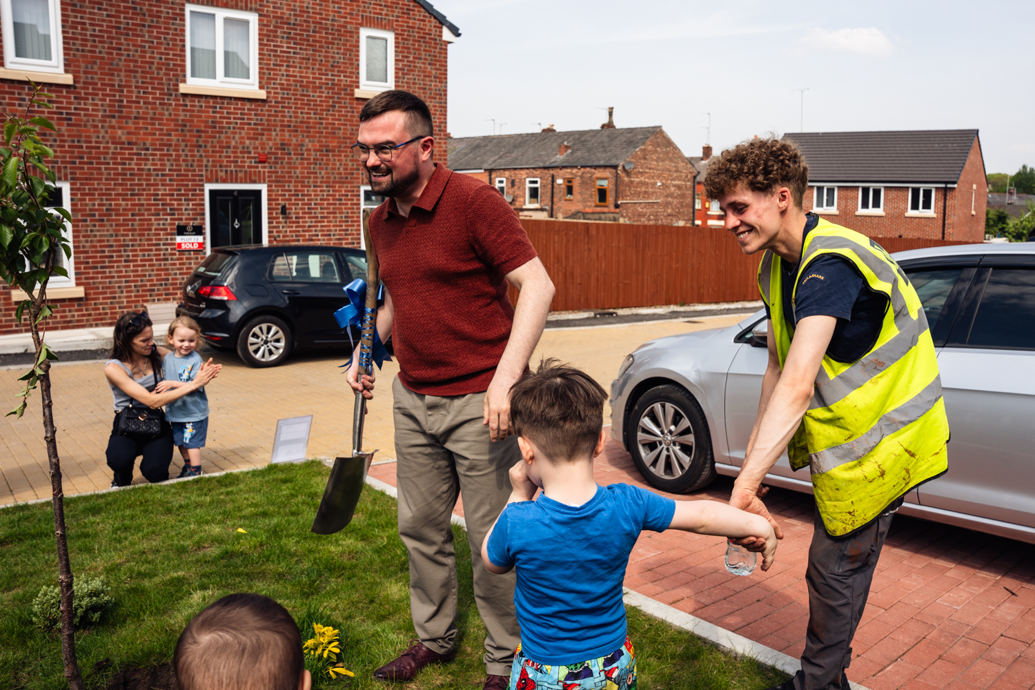 Tree being planted by councillor meredith with help of local children